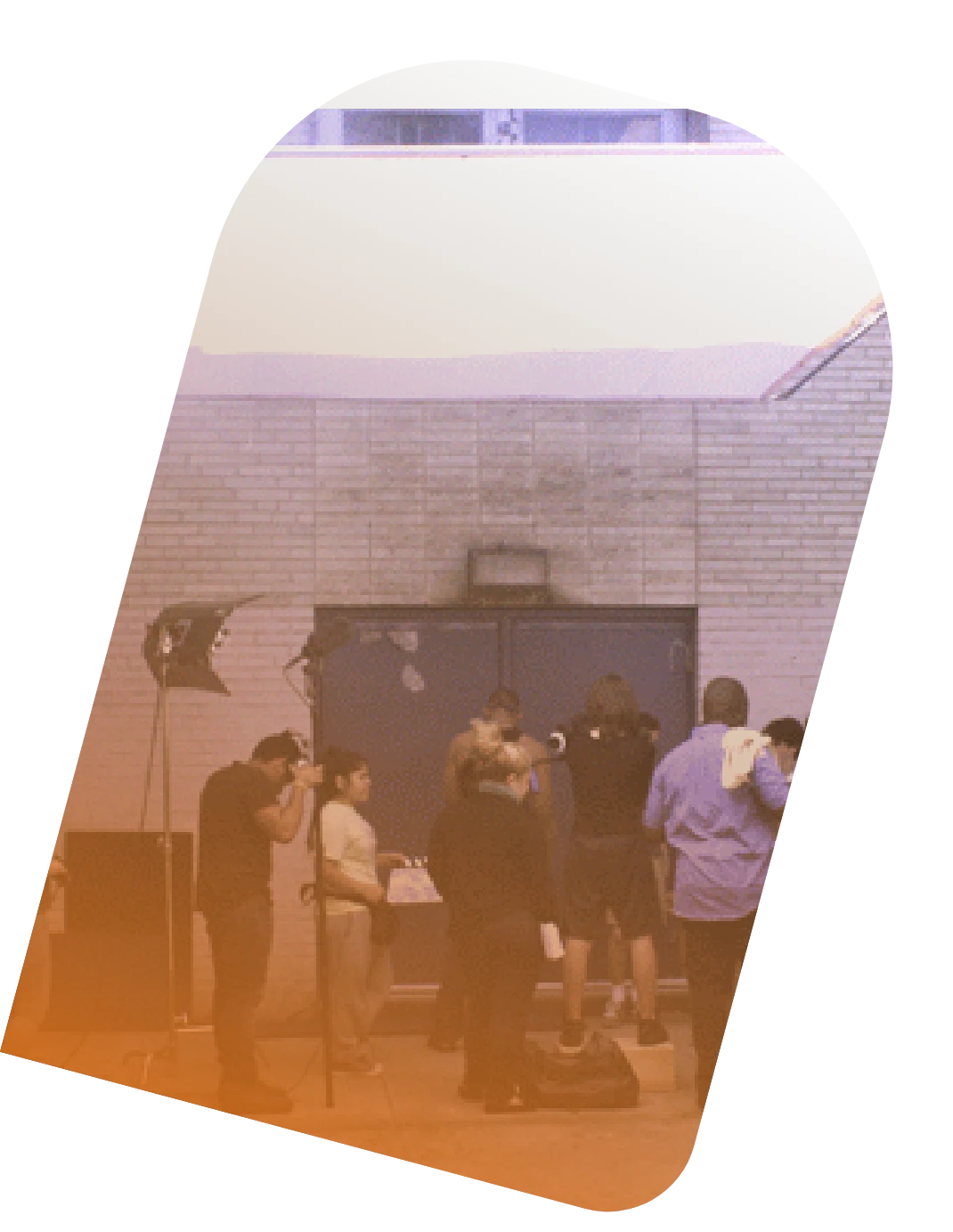 A student film crew sets up lights and a camera in a TvF studio